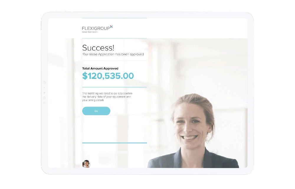 Tablet screen displaying a lease approval confirmation from FLEXIGROUP with a total approved amount of $120,535.00, showing a smiling woman in business attire in the background.