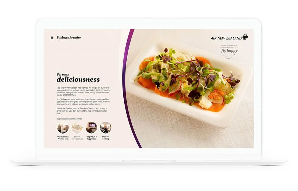 A presentation slide with a photo of a gourmet dish on a white plate, consisting of vegetables and microgreens, and promotional text for Air New Zealand's Business Premier service.