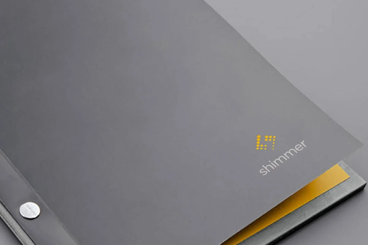 Kevin Schluter Design | Shimmer Branding | Application | A close-up of a sleek, modern shower panel or control with a yellow LED display showing the number 67 and the word 'shimmer' below it, set against a gray background.