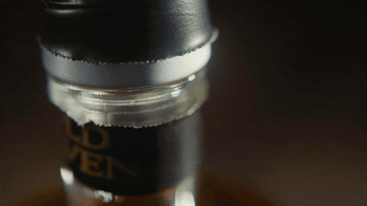 Close-up of a small black bottle with gold text on it.