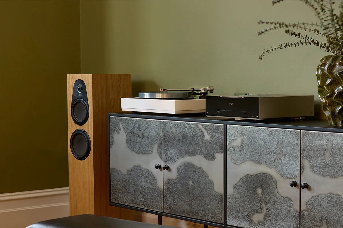 A modern living space with plants, and a Linn Selekt Music System with DSM and 150 Loudspeakers.