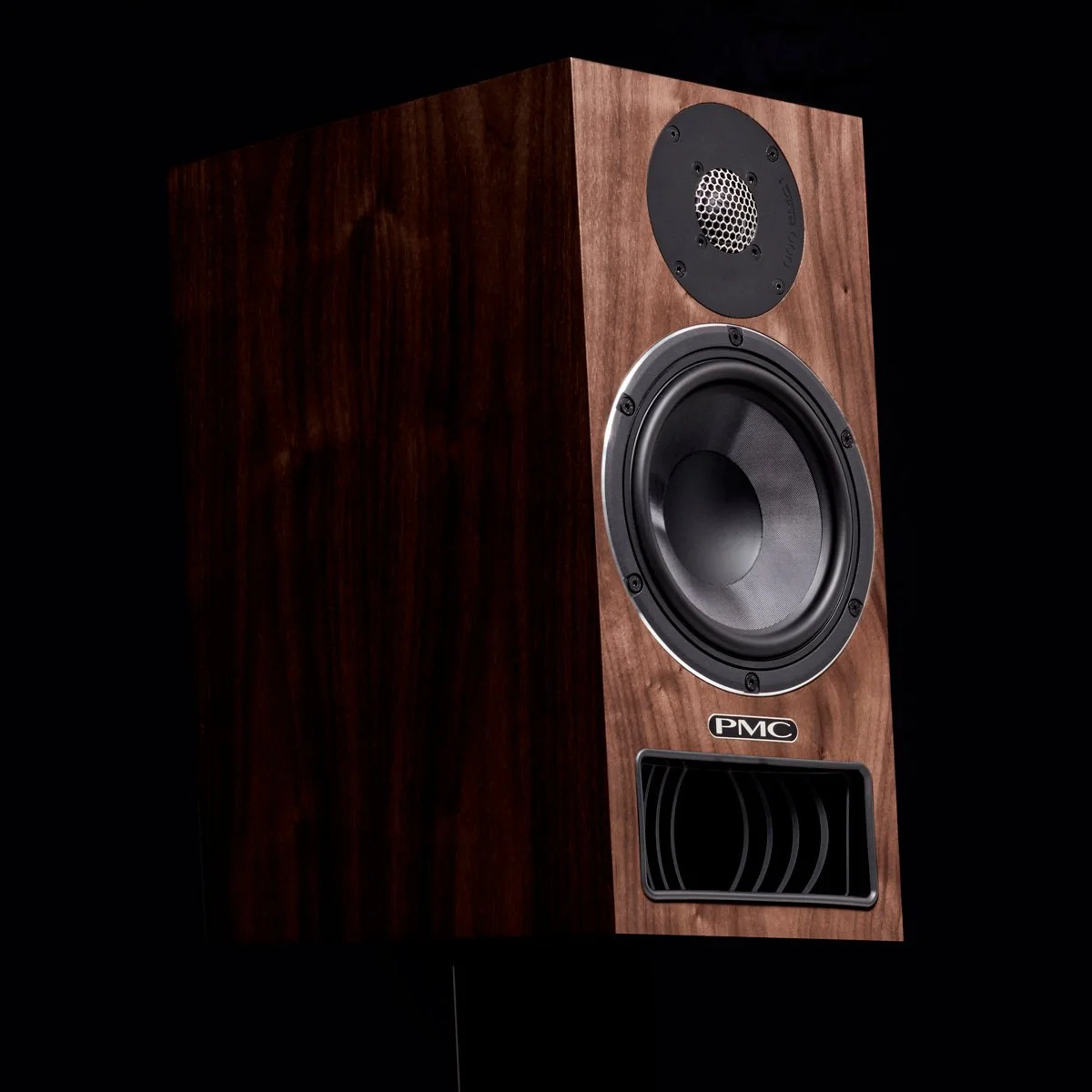 PMC Twenty.21i bookshelf speaker with a black tweeter and a large black woofer, branded with PMC, set against a black background.