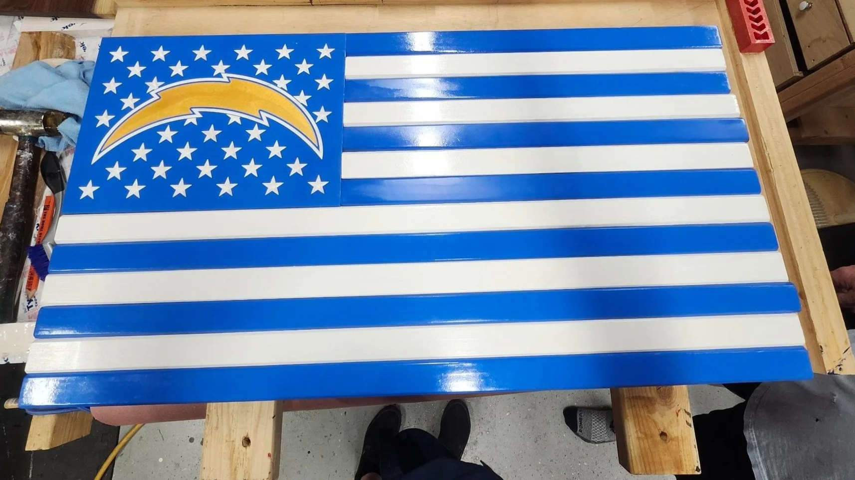 Wooden American flag with blue and white stripes, featuring stars and a lightning bolt design in the canton.