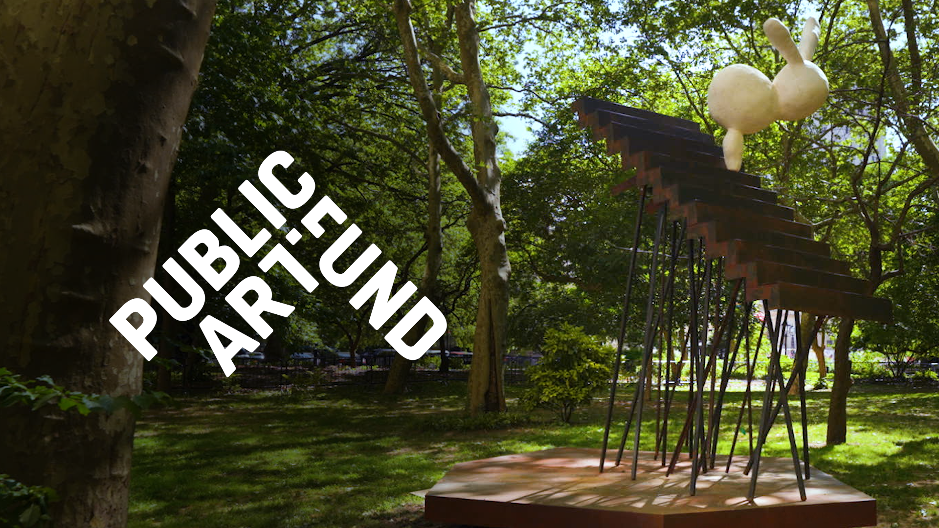 Outdoor sculpture of a rabbit climbing stairs, surrounded by trees and grass, with "Public Art Fund" text.