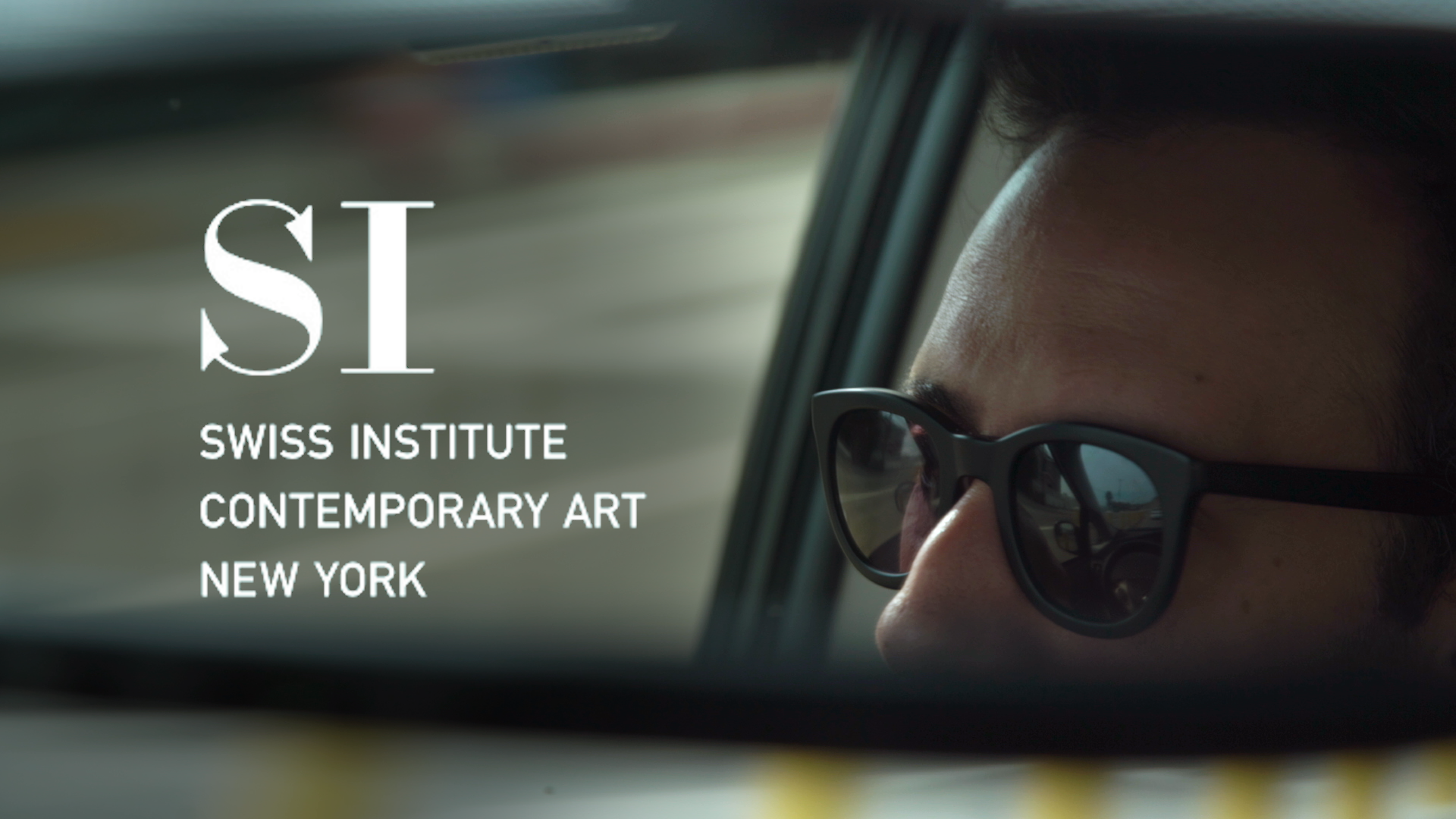 Side mirror reflection of a person wearing sunglasses with "Swiss Institute Contemporary Art New York" text overlay.