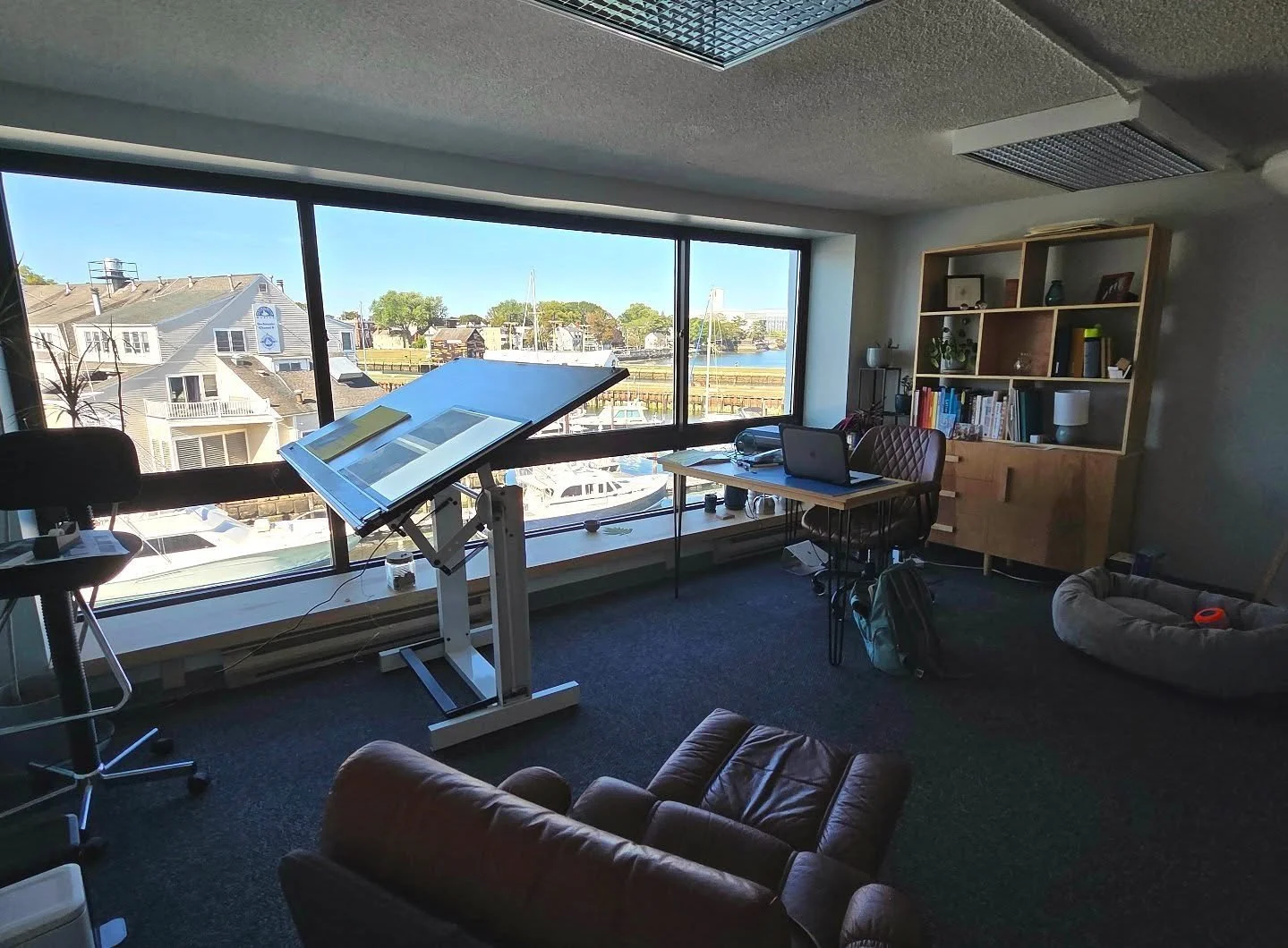 Getting out of the house after working from home for five years has been such a welcome change! I also lucked out finding a free standing drafting table, chair, and lamps for free. It's great to stand and draw while looking out over Salem Harbor!