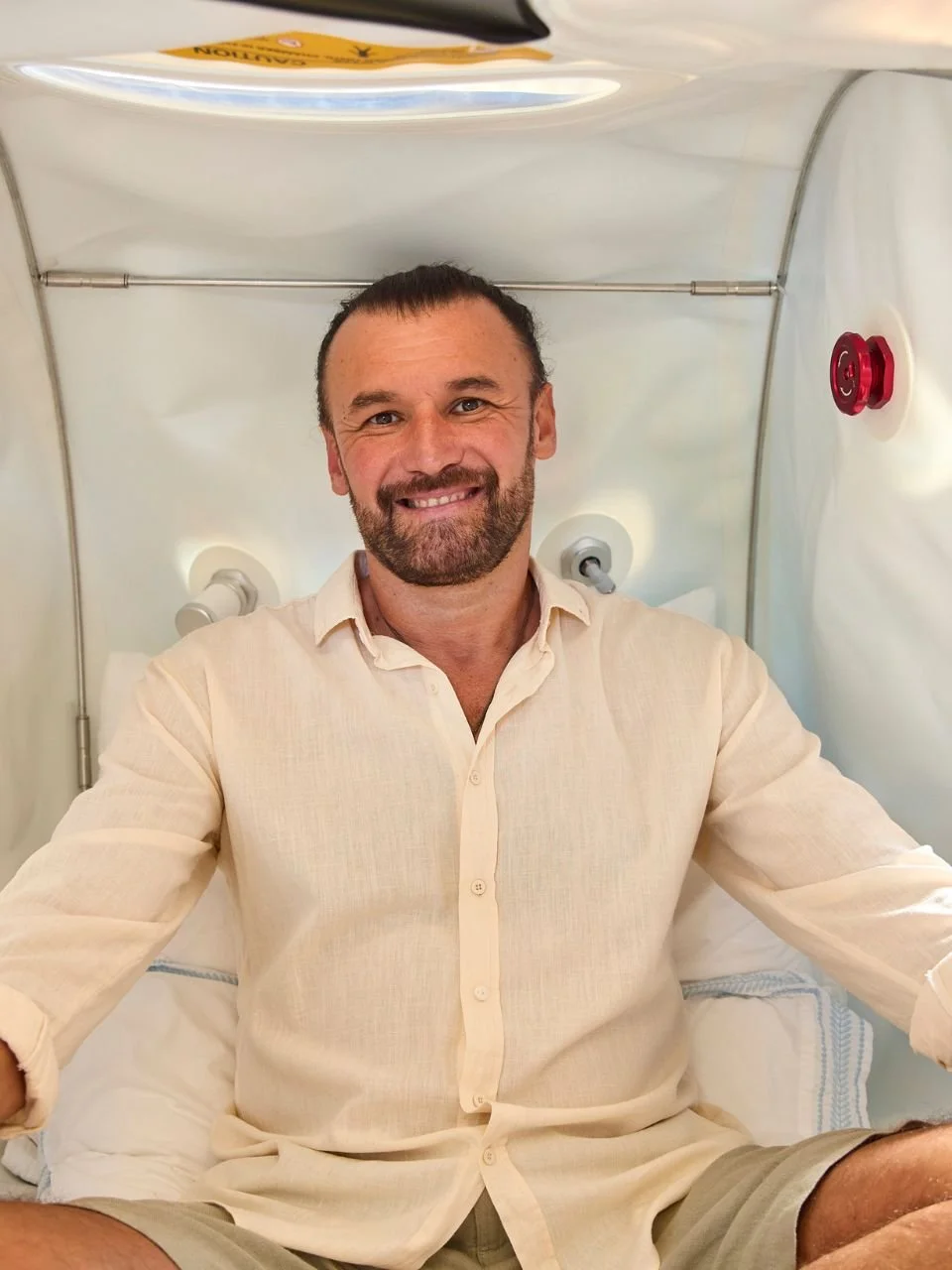 A person relaxing inside a Cocoon hyperbaric oxygen chamber at home