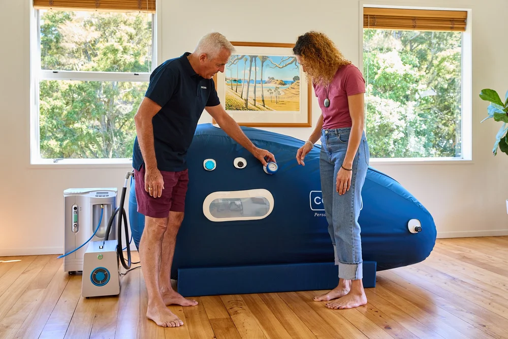 Dr Gary and Dr Lorene Dennis with a Cocoon hyperbaric chamber