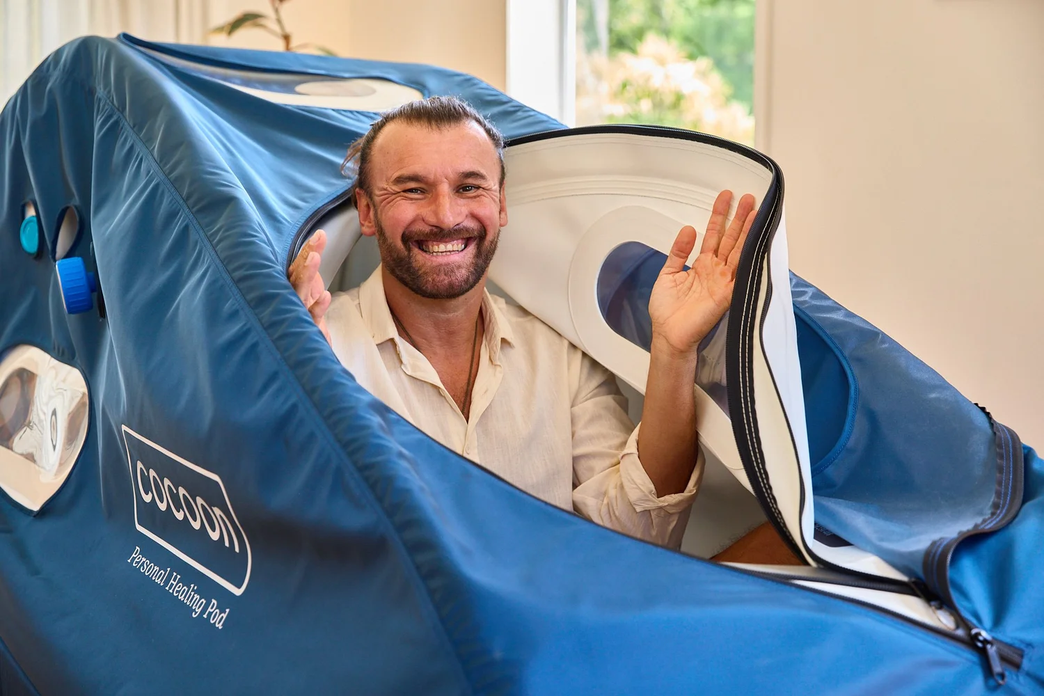 A person resting and recovering in a Cocoon at-home hyperbaric chamber