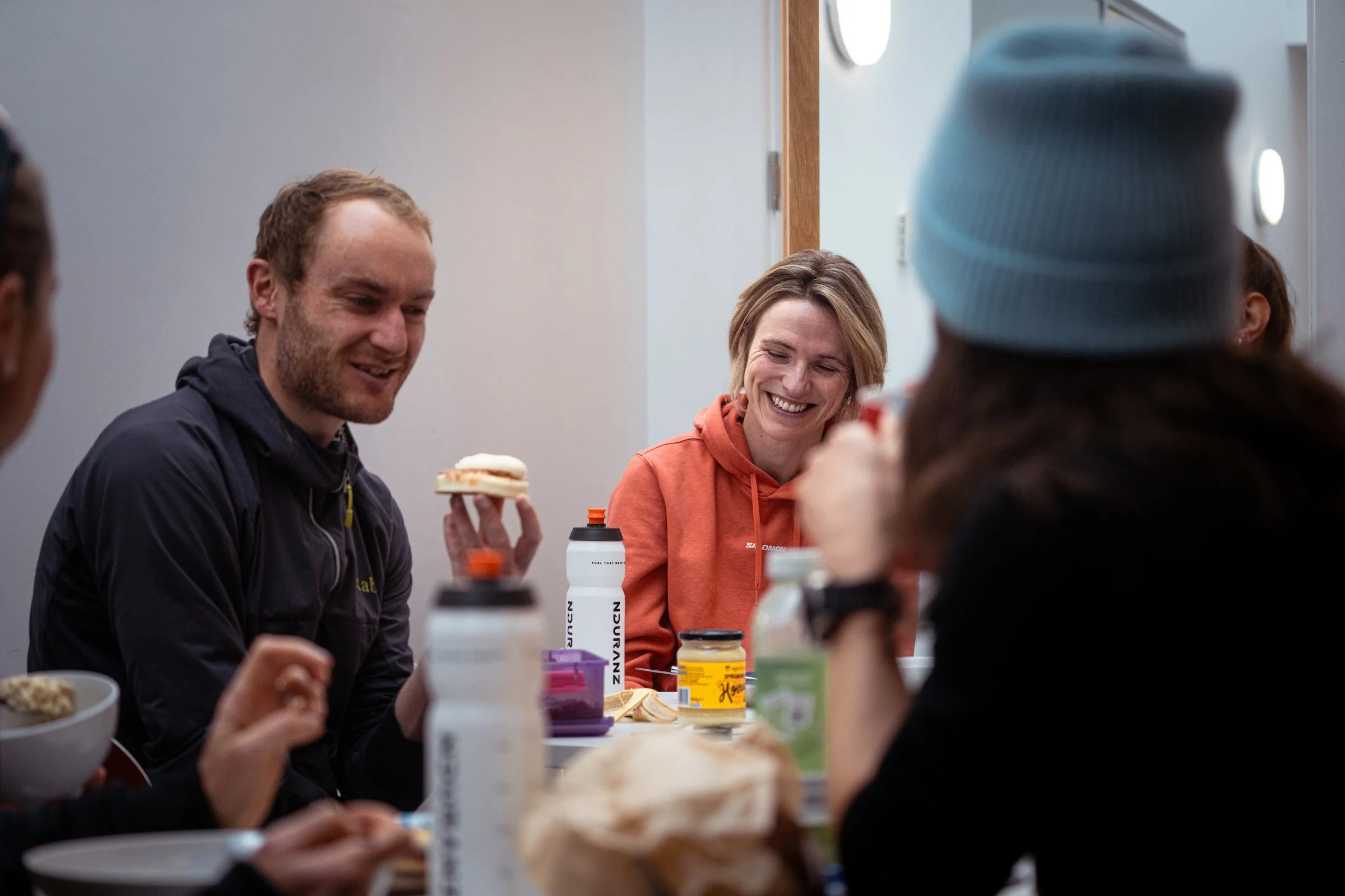 a man and two women chat and eat snacks