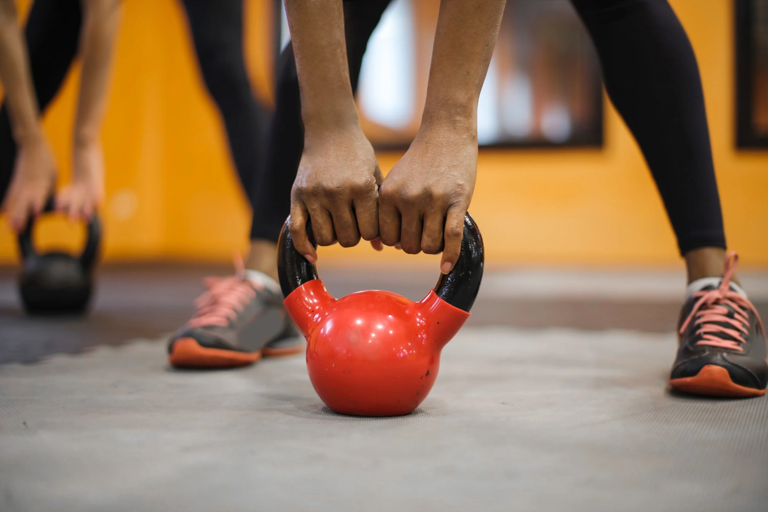 A client of 4Life Chiropractic's injury prevention services lifts a red weight in Brownsburg, Indiana.