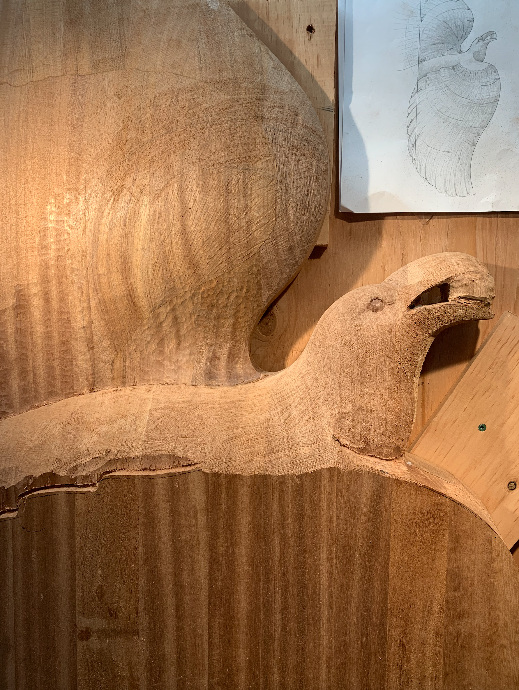 Carved raven detail in a mahogany entrance door with stained glass elements.