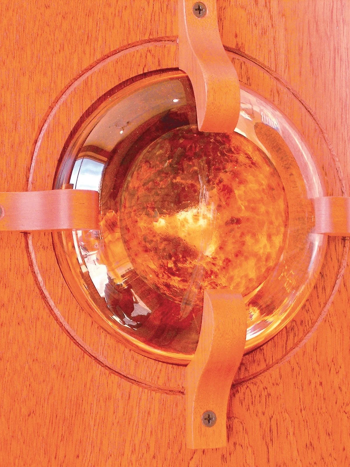 A sculptural interior passage exploring continuity, connection, and light through carved mahogany and handblown glass.