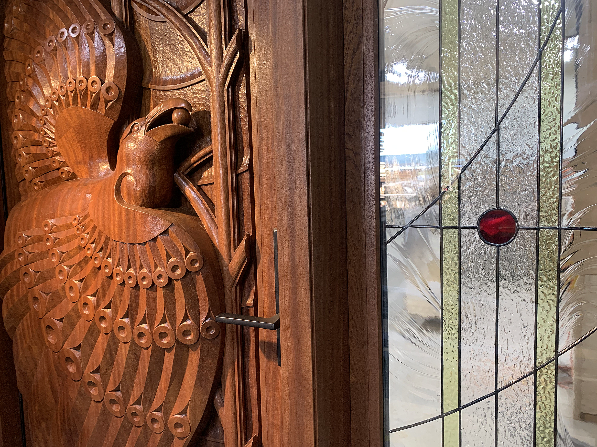 Hand-carved mahogany entrance door inspired by the Inuit story Raven and the Berry