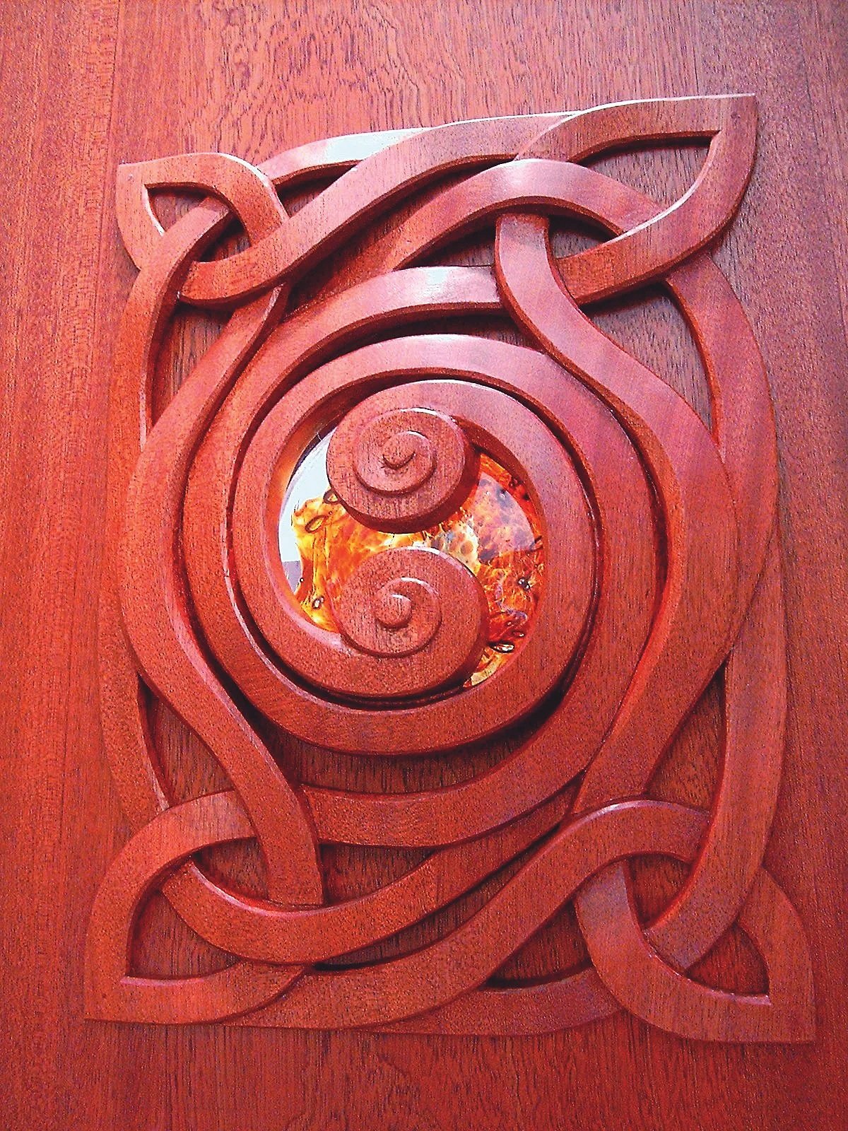 A sculptural interior passage exploring continuity, connection, and light through carved mahogany and handblown glass.