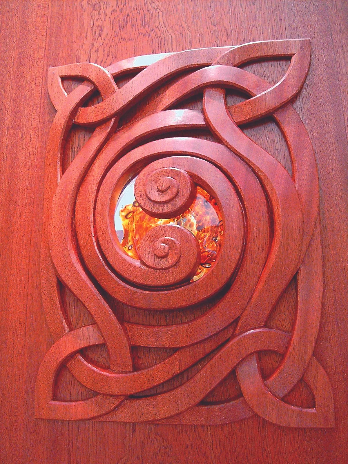 A sculptural interior passage exploring continuity, connection, and light through carved mahogany and handblown glass.