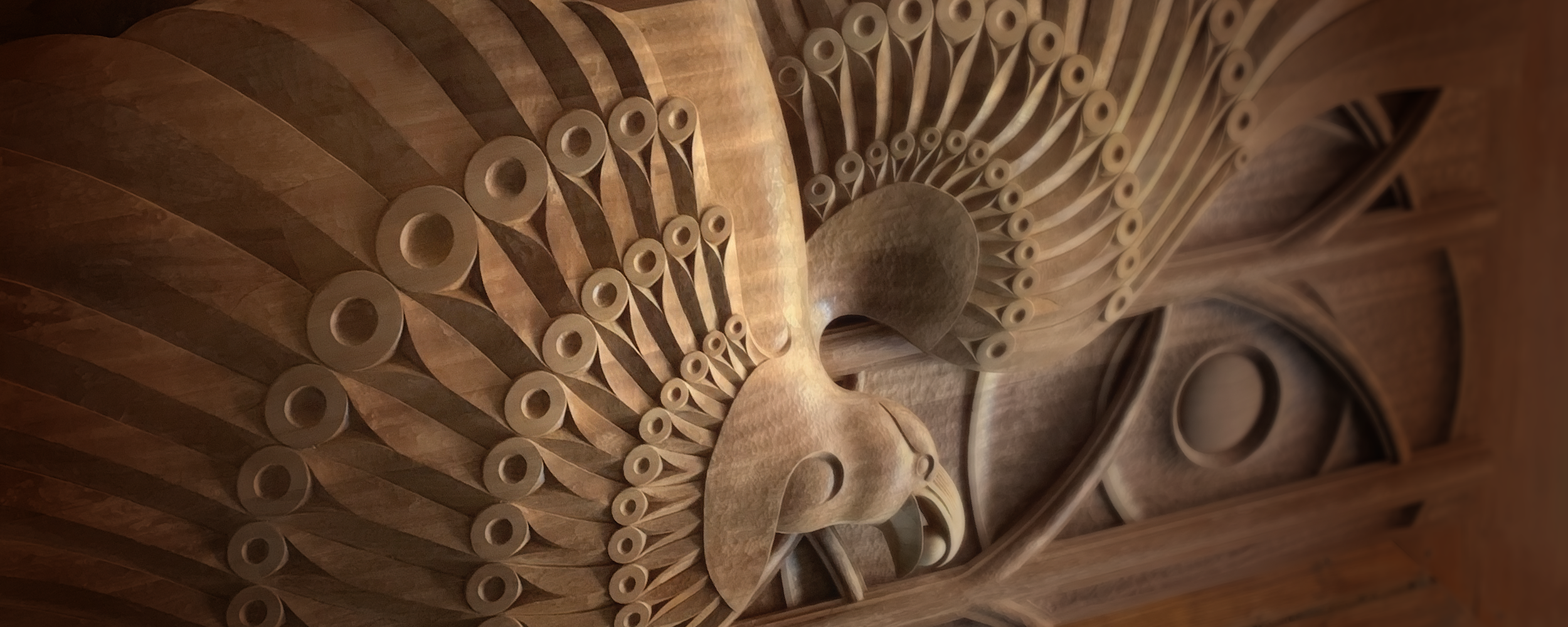 Carved mahogany panel depicting the story of the Raven and the Berry. Returning light and hope into the world.