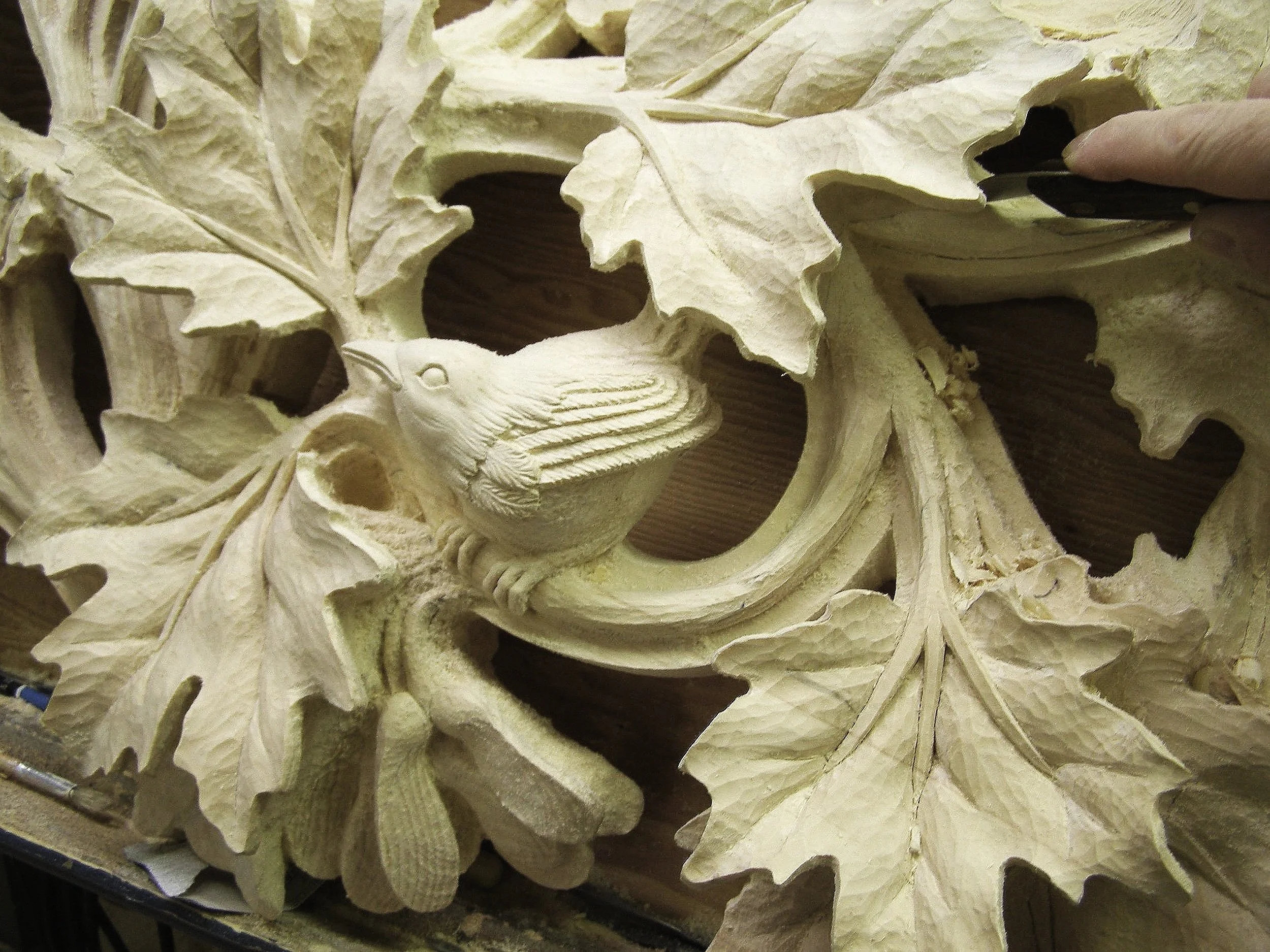Hand carving in progress in the studio using traditional woodworking tools.
