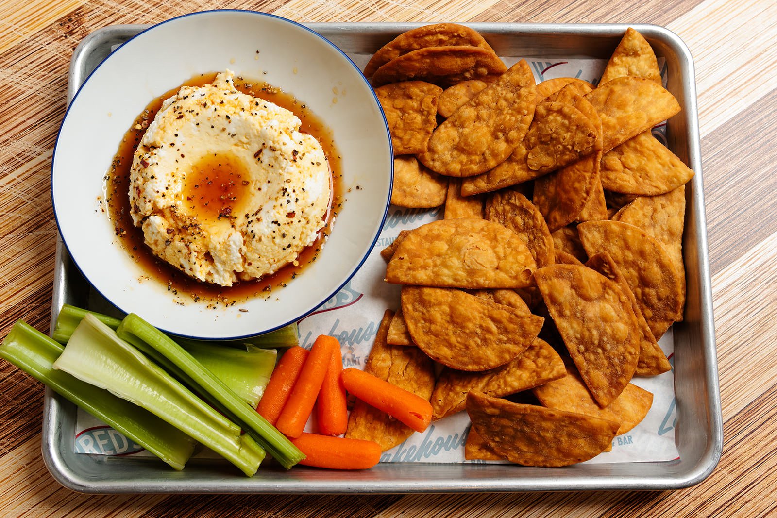 Tray of chicken tenders, celery sticks, baby carrots, mashed potatoes with gravy, and a bowl of mashed potatoes with gravy and black pepper.