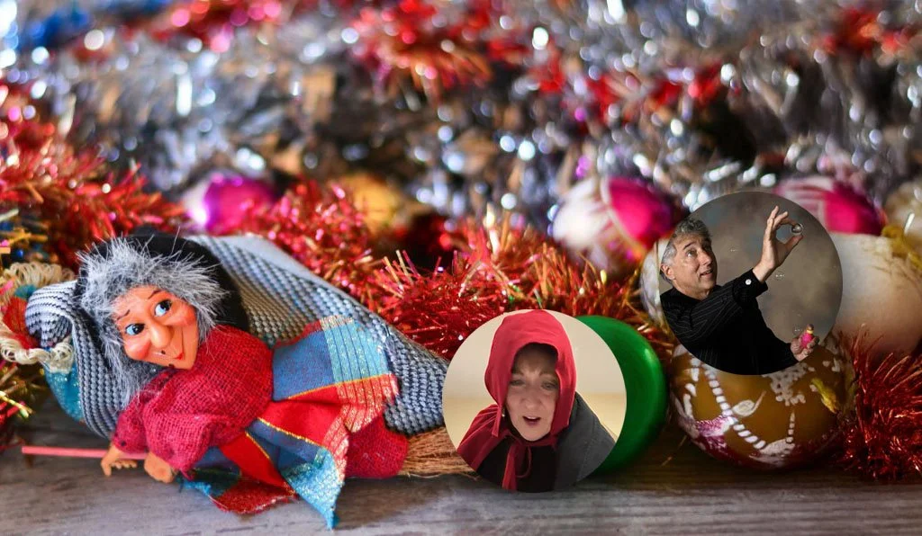 Hanging colorful witch dolls in a street market with a historical building in the background.