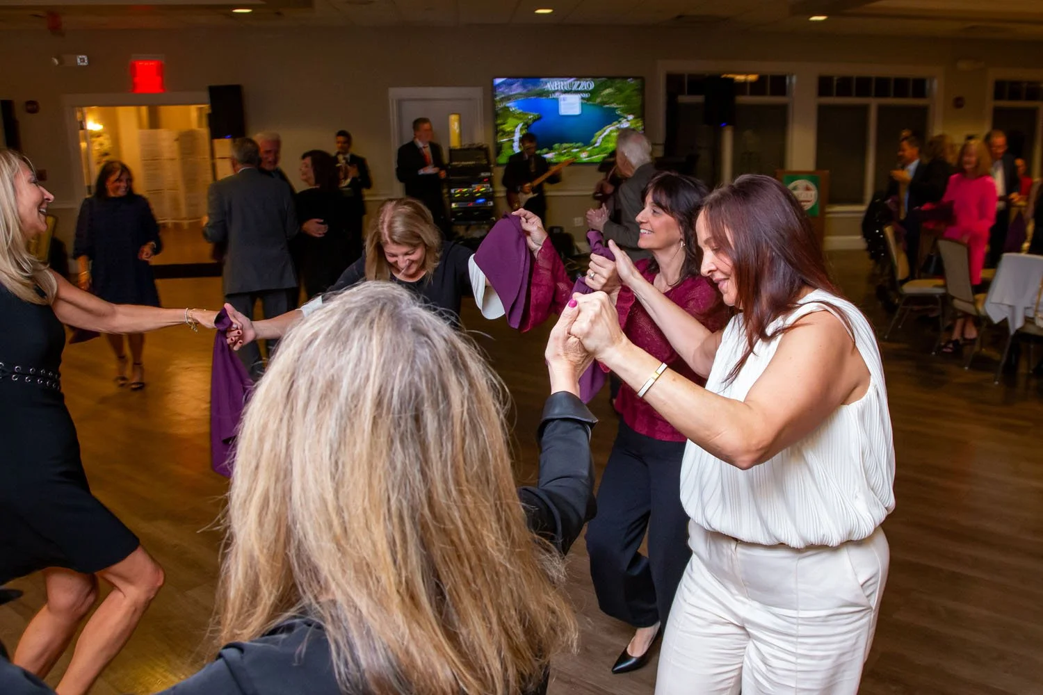 People dancing and enjoying music at a social event or party in an indoor venue.