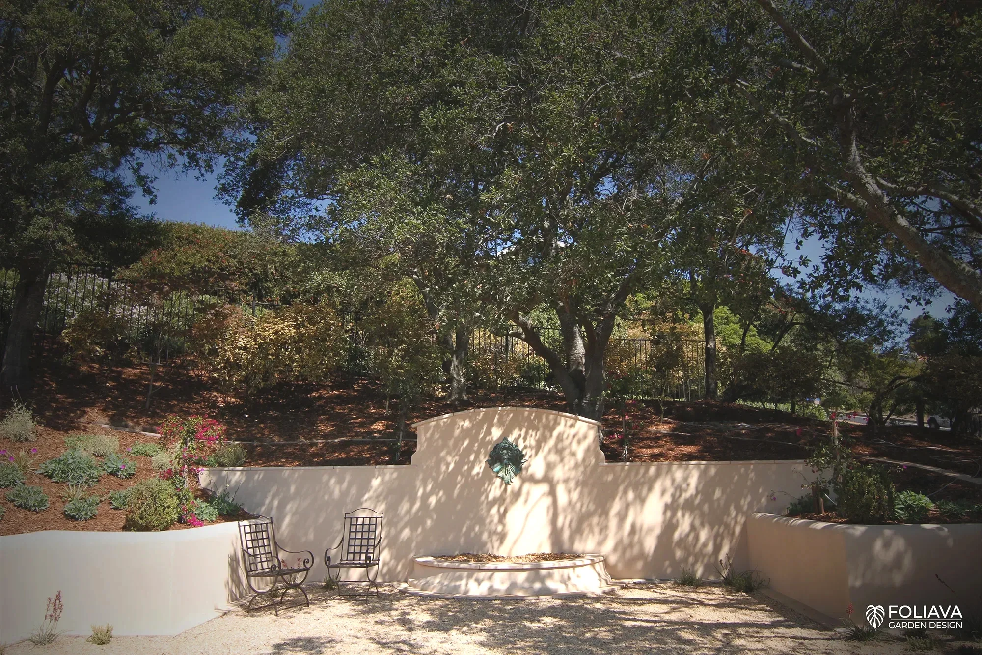 Stucco garden walls and stone stairs create timeless elegance with a European courtyard fountain and feel.