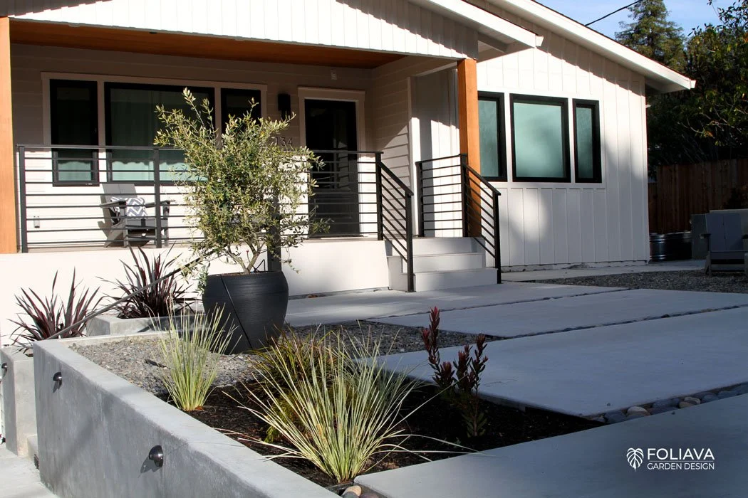 Modern craftsman home entrance with poured-in-place concrete slabs and new walls.
