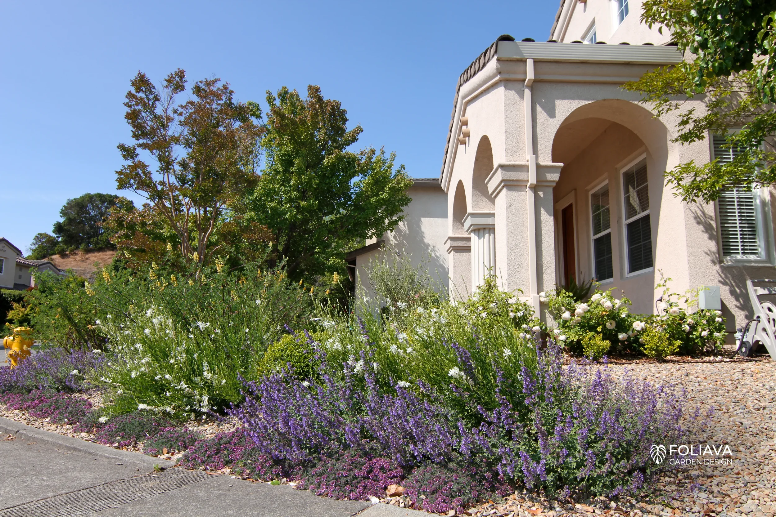 Front lawn transformed into a Monet-inspired garden with pastel flowers.