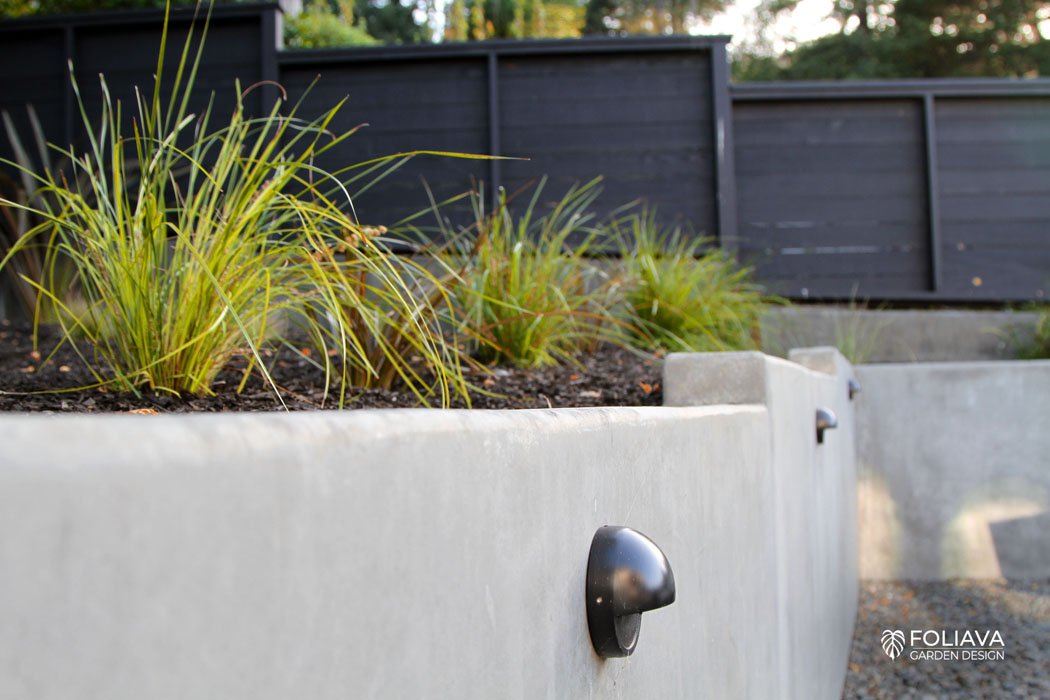 Modern concrete walls with built-in lighting for a secure entrance into the craftsman house.
