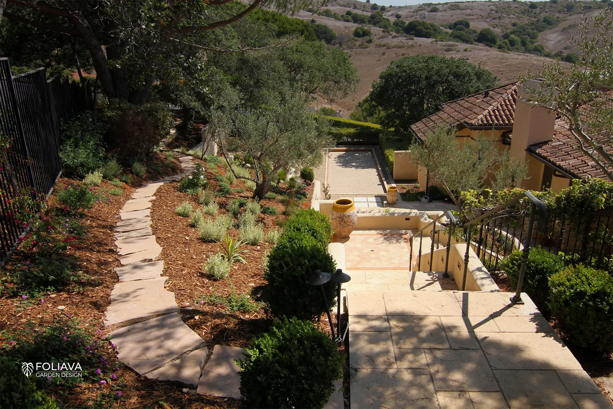 Elegant bocce court with stucco walls and olive trees, blending European charm with California living.
