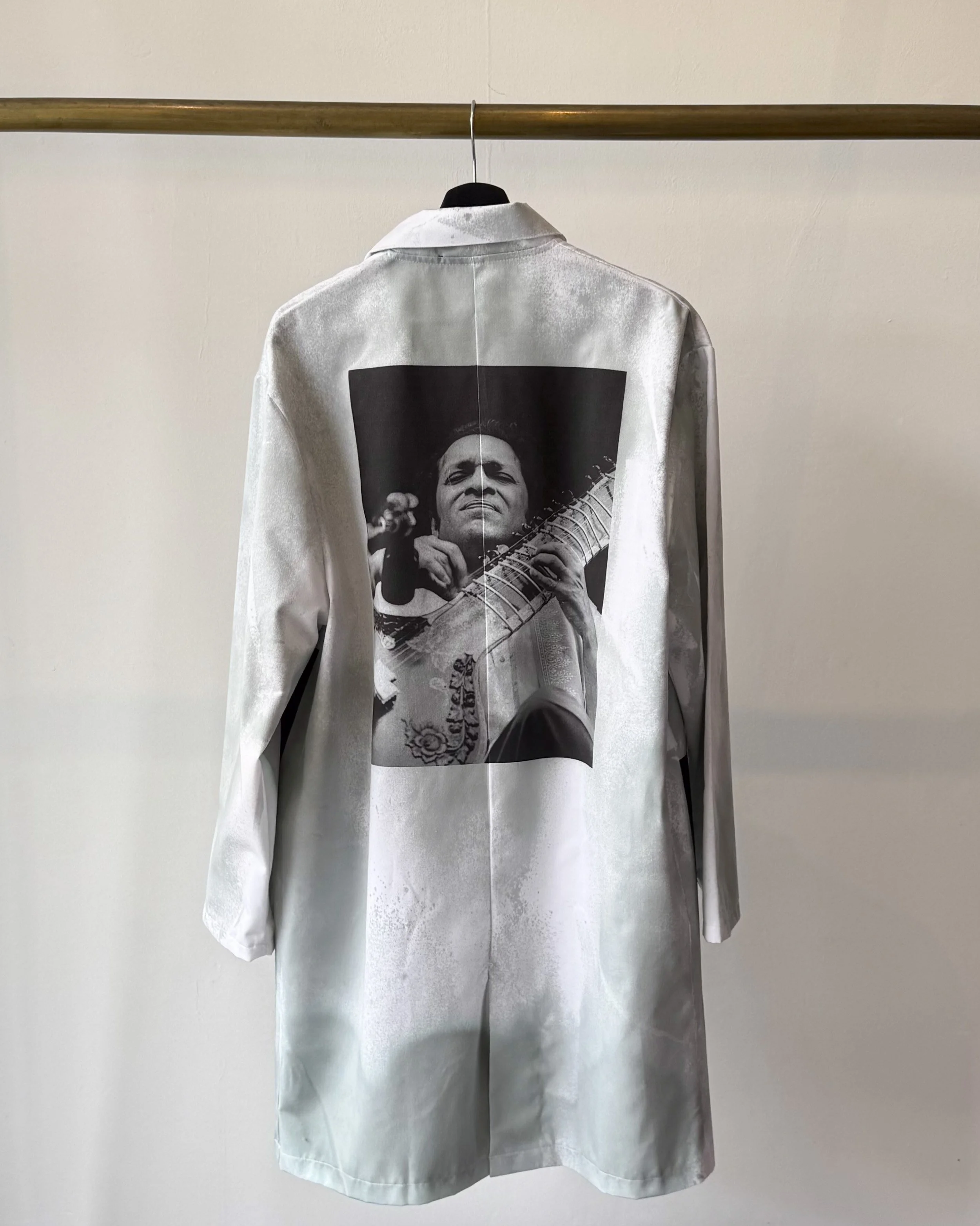 Back view of lab coat with oxidised treatment and featuring an image in the centre back of Ravi Shankar playing the sitar..jpg