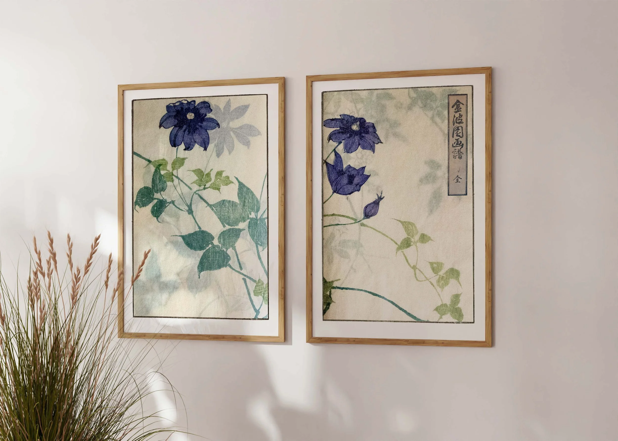 Framed set of two prints of Bunpo Kawamura’s Burukuremachisu set with blue clematis flowers on a sunlit wall.