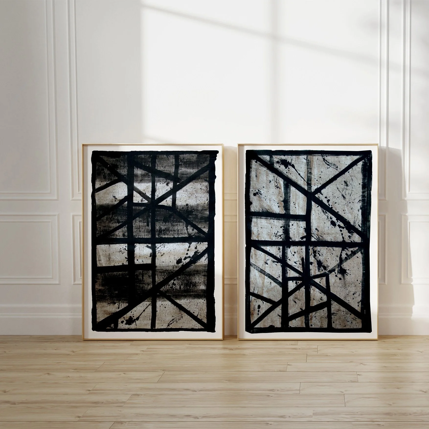 Set of two framed abstract line art prints (Flint1, Flint6) leaning against a sunlit wall.
