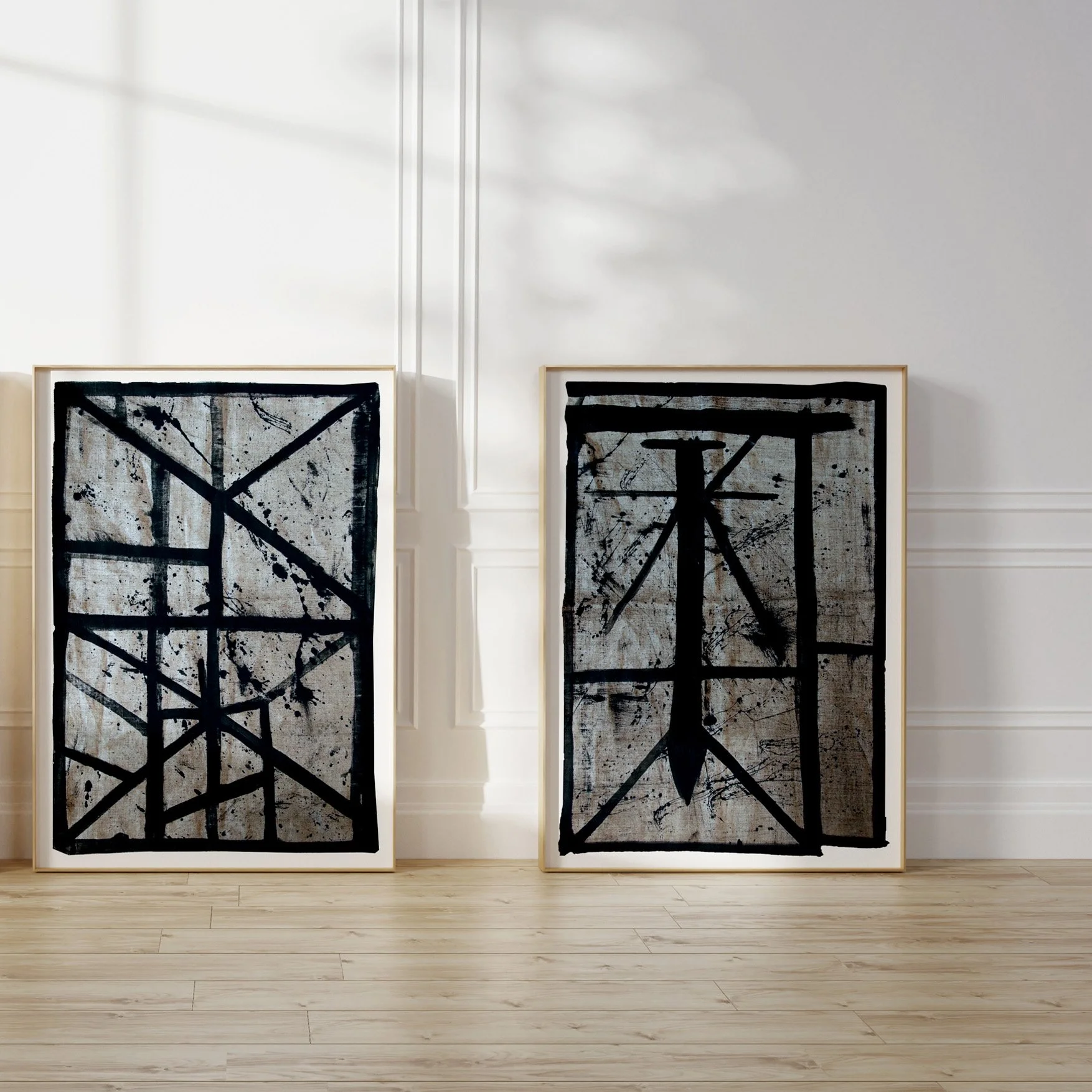 Set of two framed abstract line art prints (Flint6, Flint2) leaning against a sunlit wall.