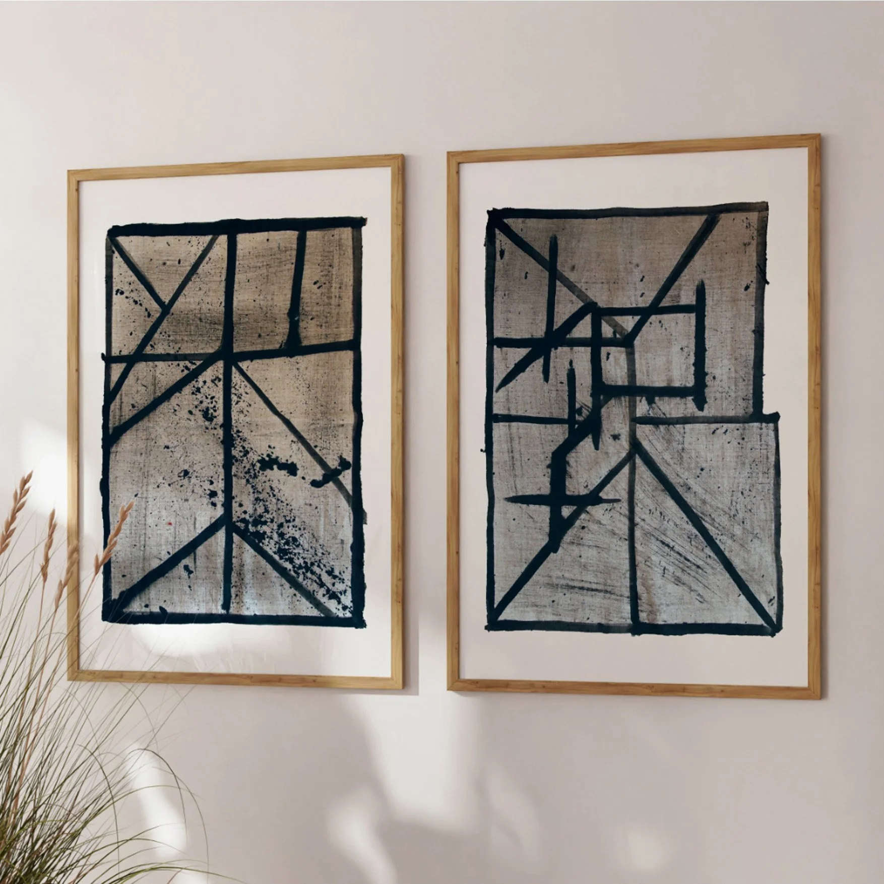 Set of two framed abstract line art prints (Flint 3, Flint 5) leaning against a sunlit wall.