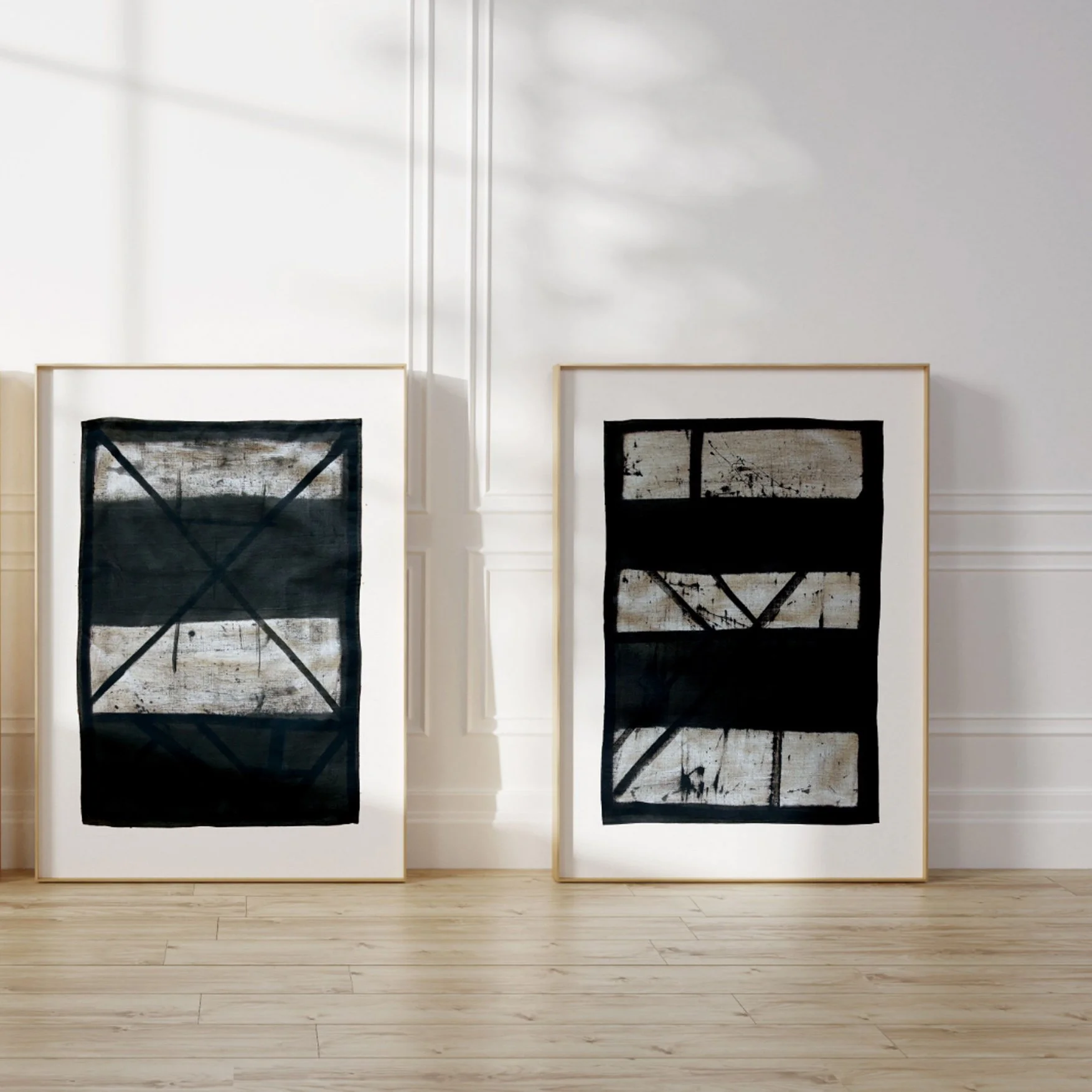 Set of two framed abstract line art prints (Flint 7, Flint 9) leaning against a sunlit wall.