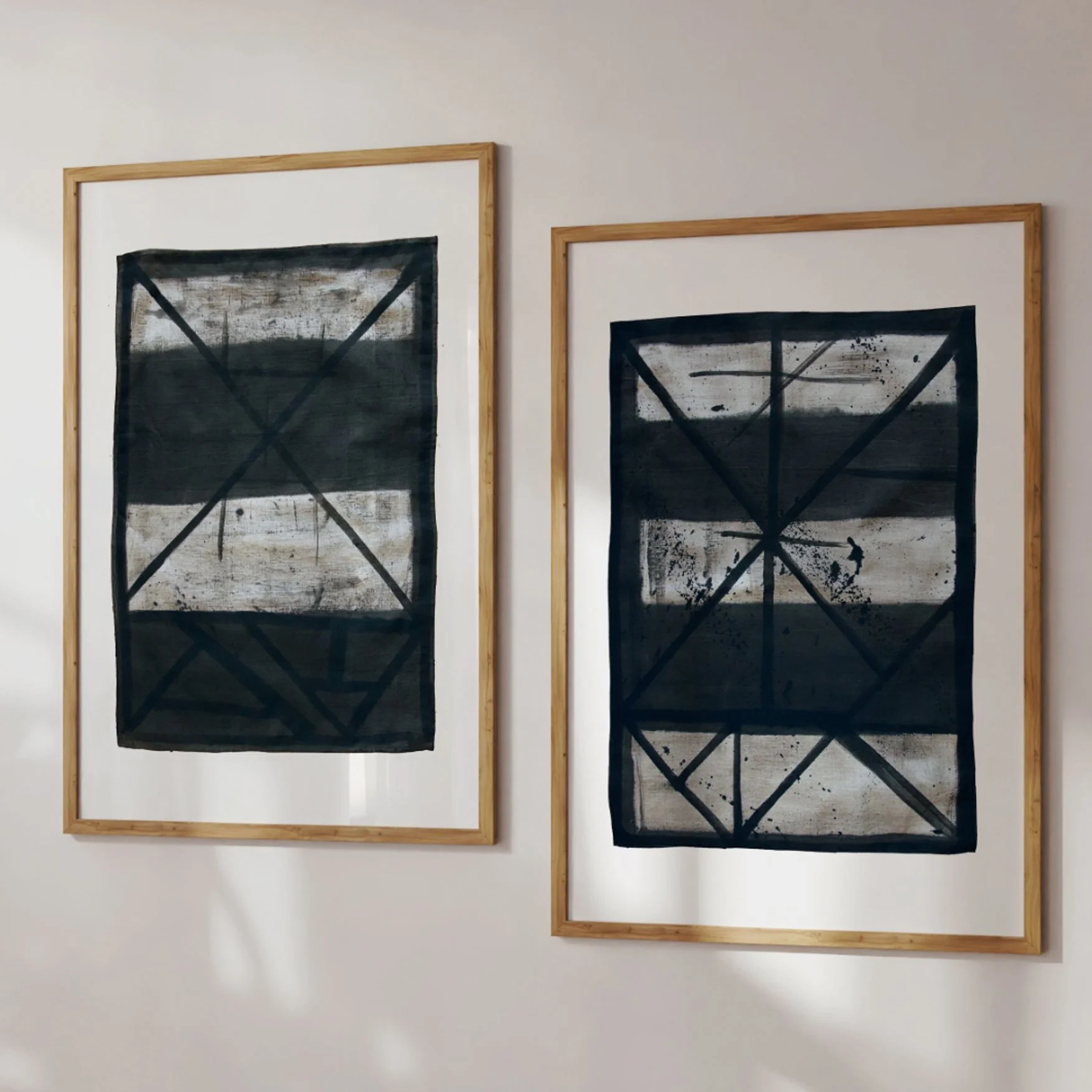 Set of two framed abstract line art prints (Flint 9, Flint 10) leaning against a sunlit wall.