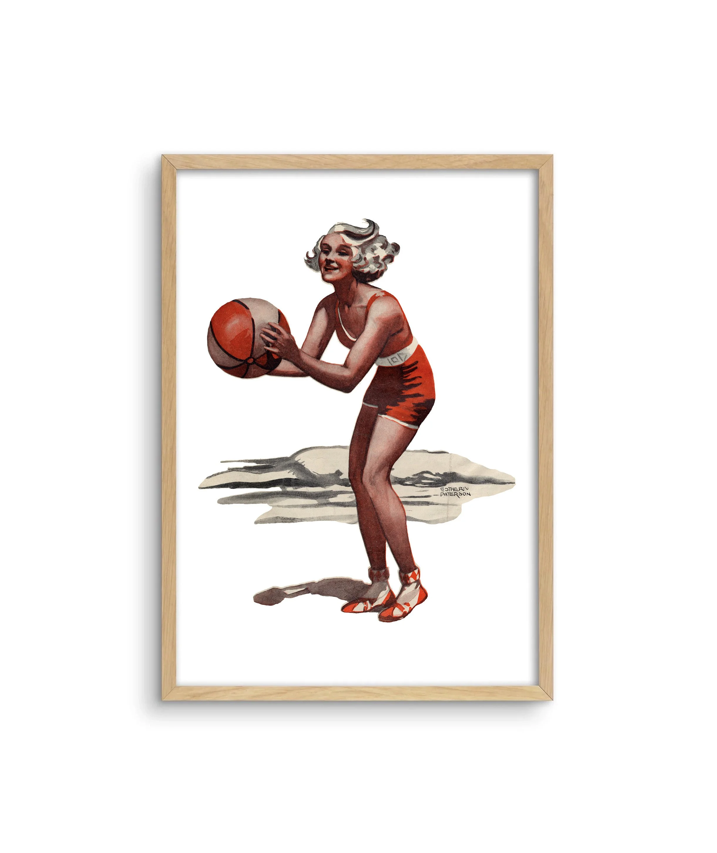 A framed print of the Australian beachside with a portrait of a girl dressed in red playing with a beach ball.