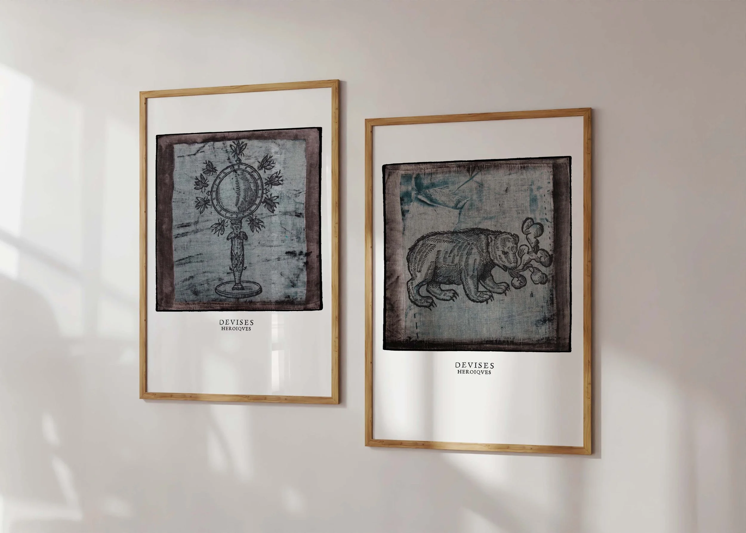 Two framed decorex prints on a wall with illustrations by Claude Paradin.