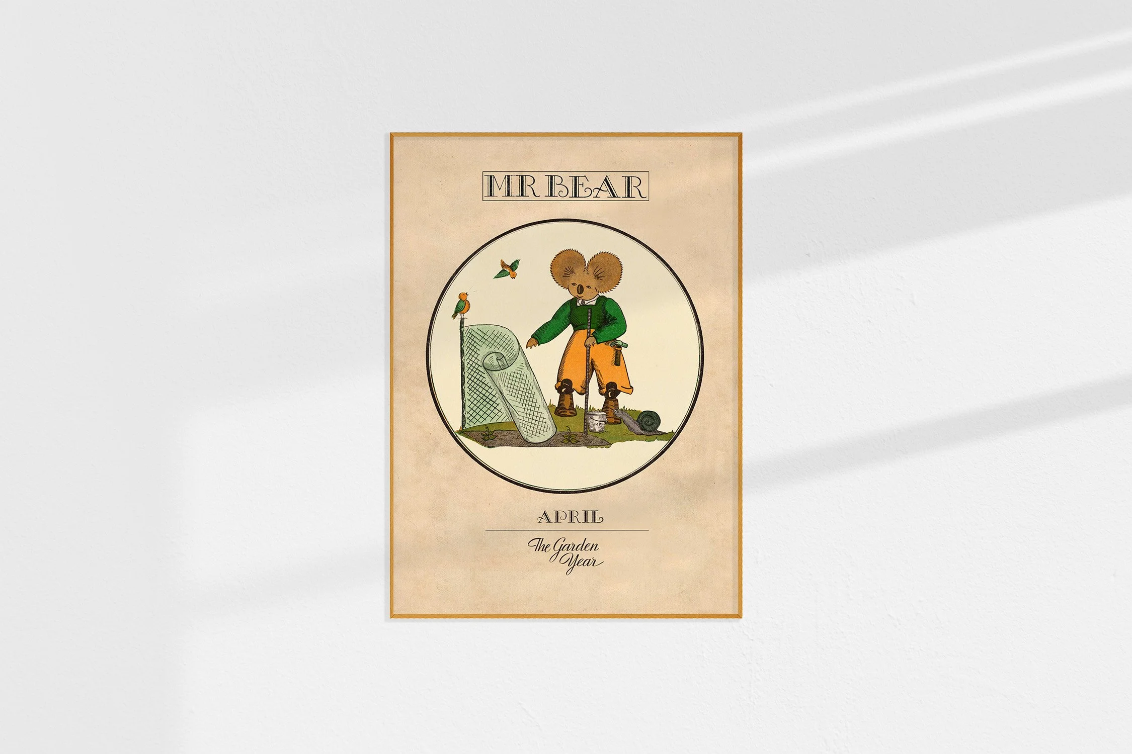 A framed Oz Print with a koala Mr Bear in a roundel making a screen in the garden.