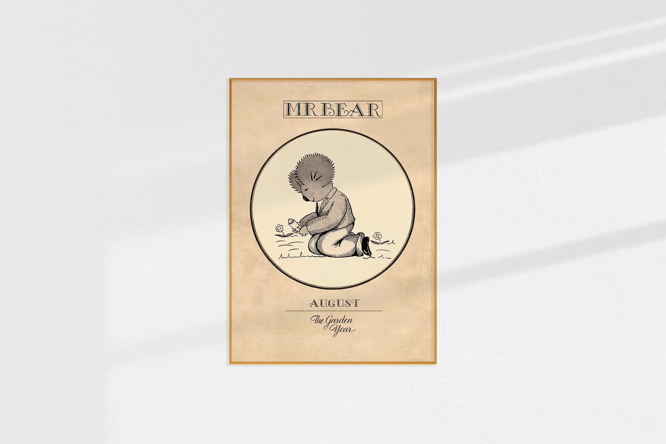 A framed Oz print with a koala Mr Bear in a roundel kneeling with a packet of seeds.
