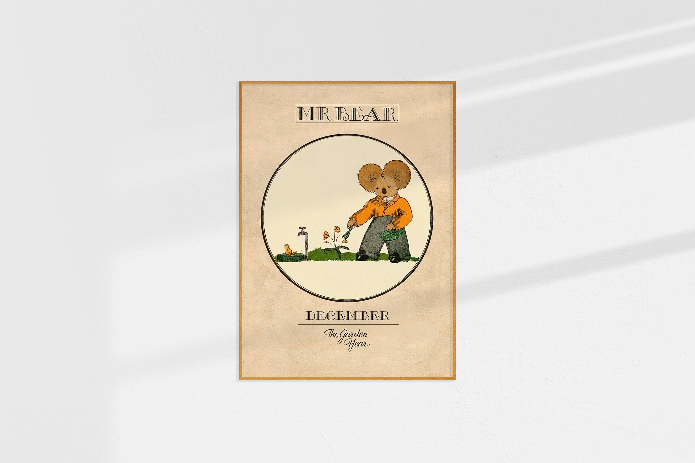 A framed Oz print with a koala Mr Bear in a roundel cutting flowers.