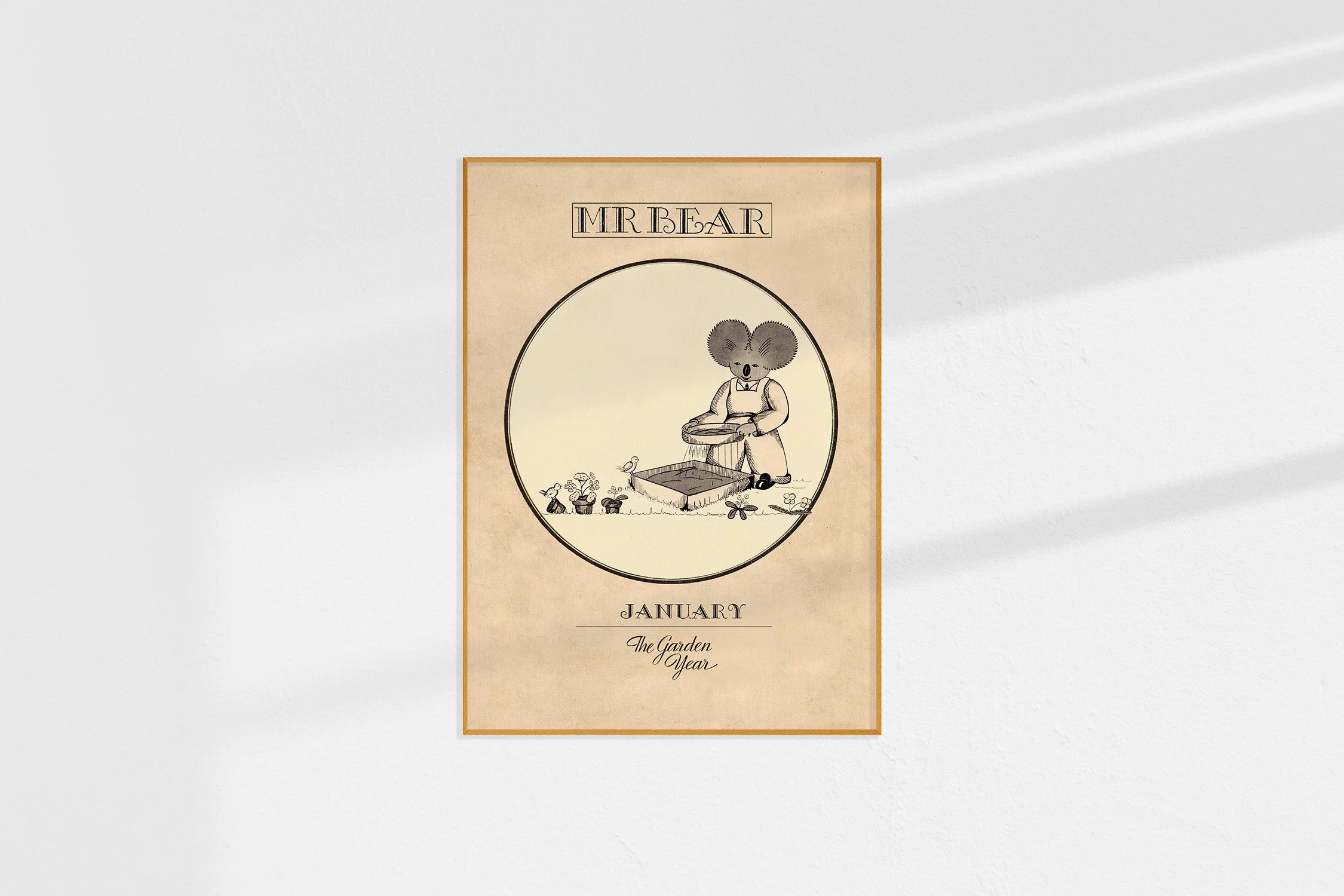 A framed Oz print of a koala Mr Bear in a roundel sifting sand on a tray of seedlings.
