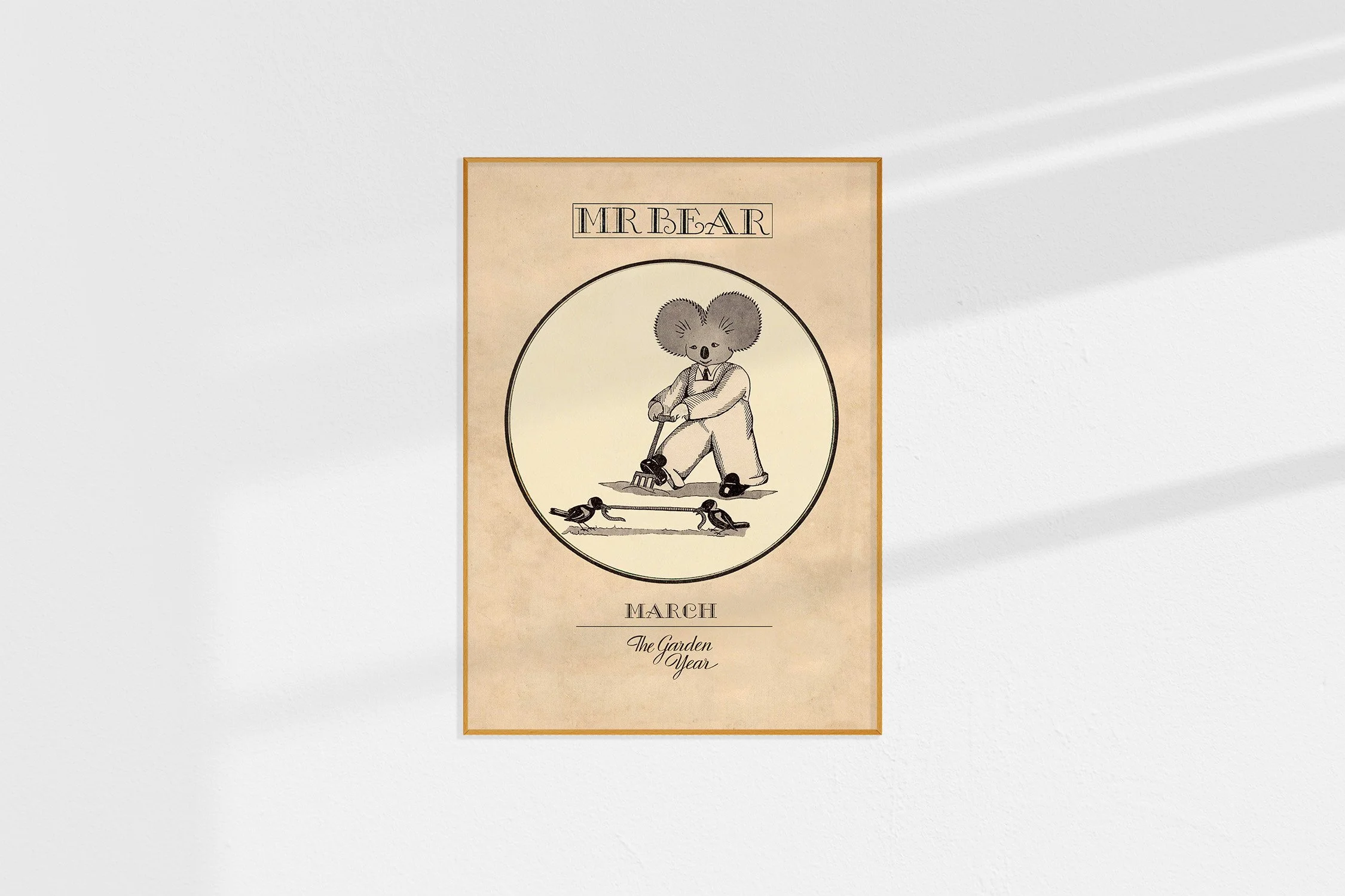 A framed Oz print with a koala Mr Bear in a roundel digging with a fork and birds fighting over a worm.