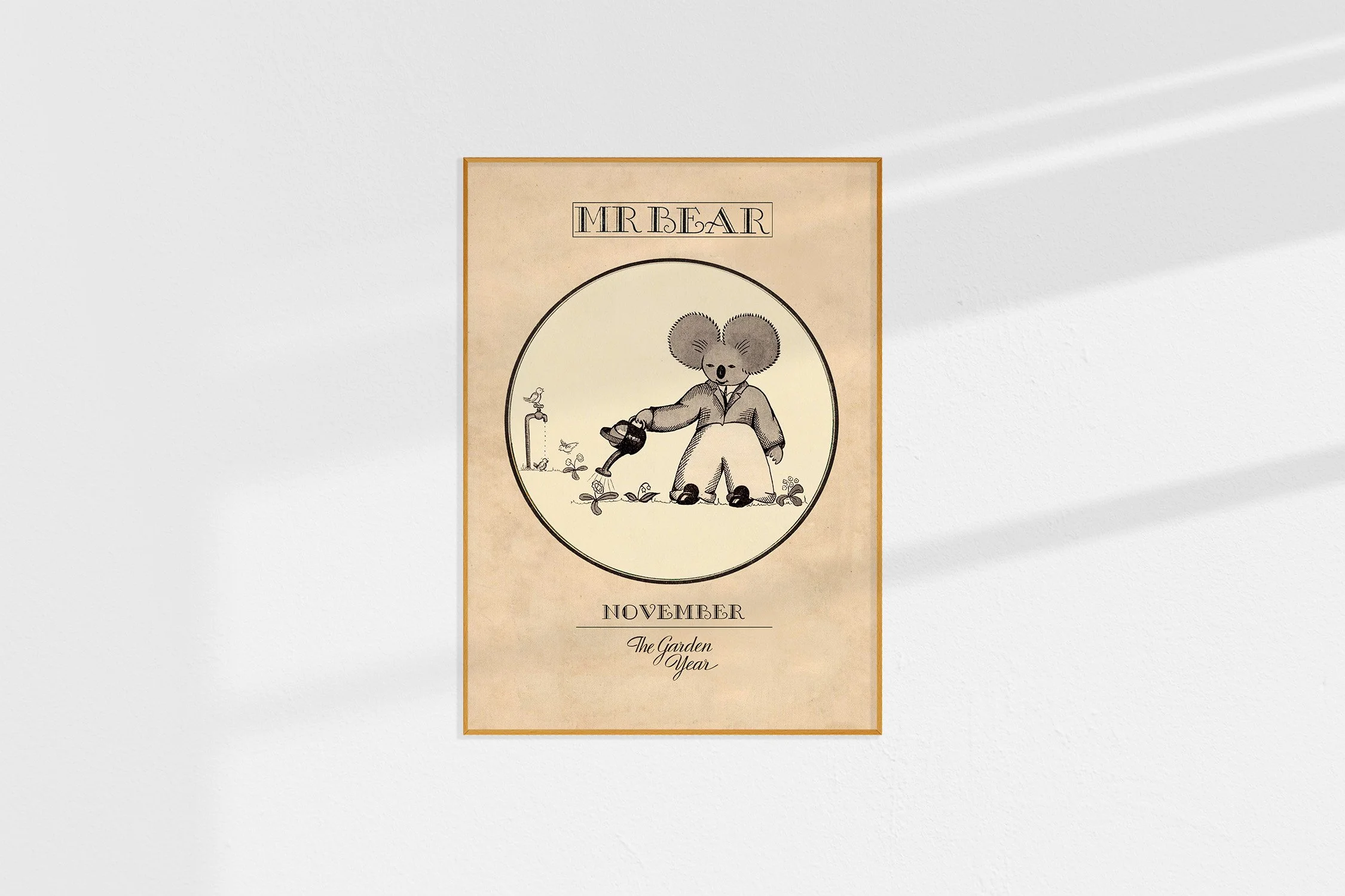 A framed Oz print with a koala Mr Bear in a roundel with a watering can and a bird sitting on a tap.