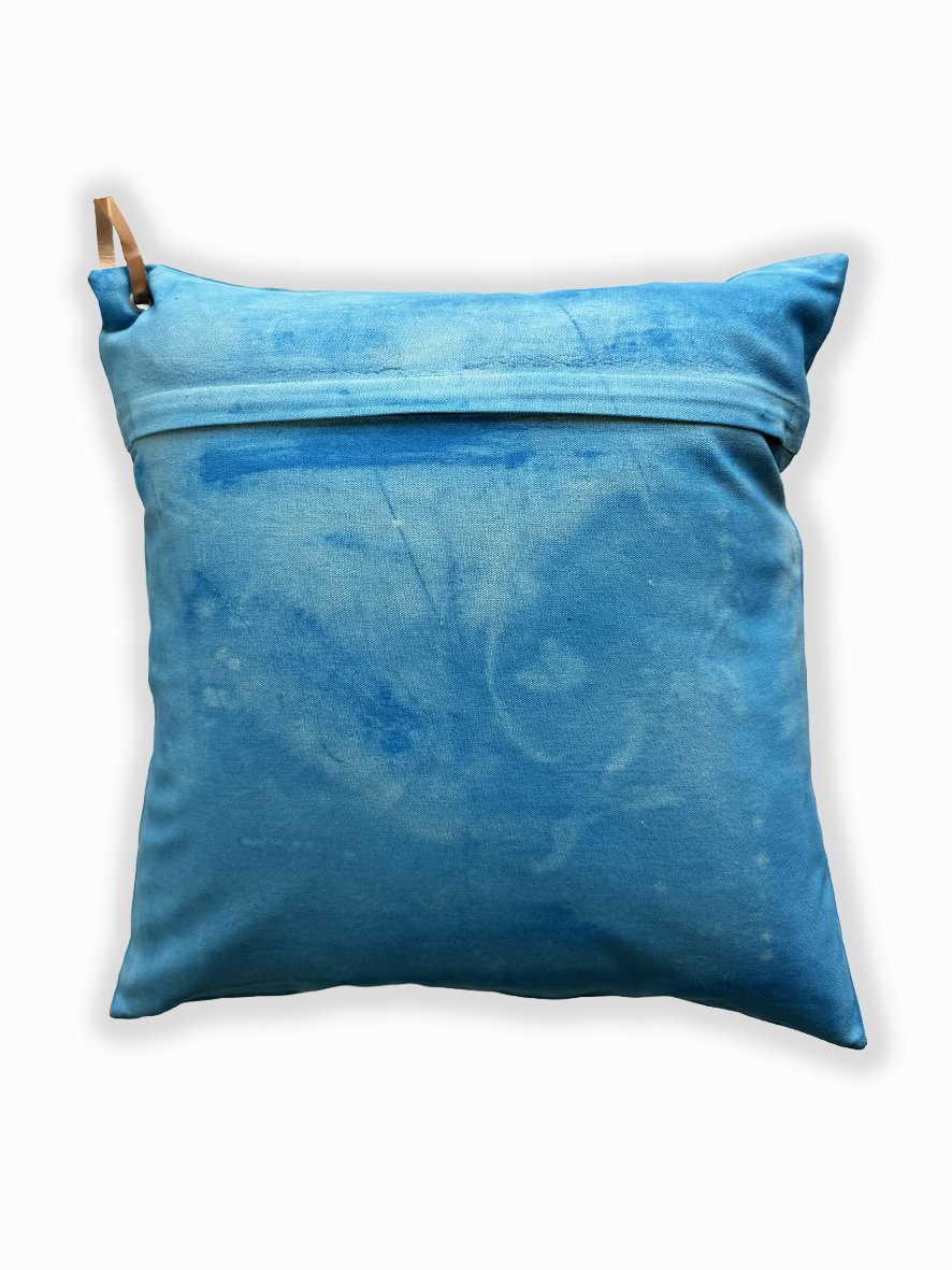 Back view of a cushion with an artistic washed background in sky blue.
