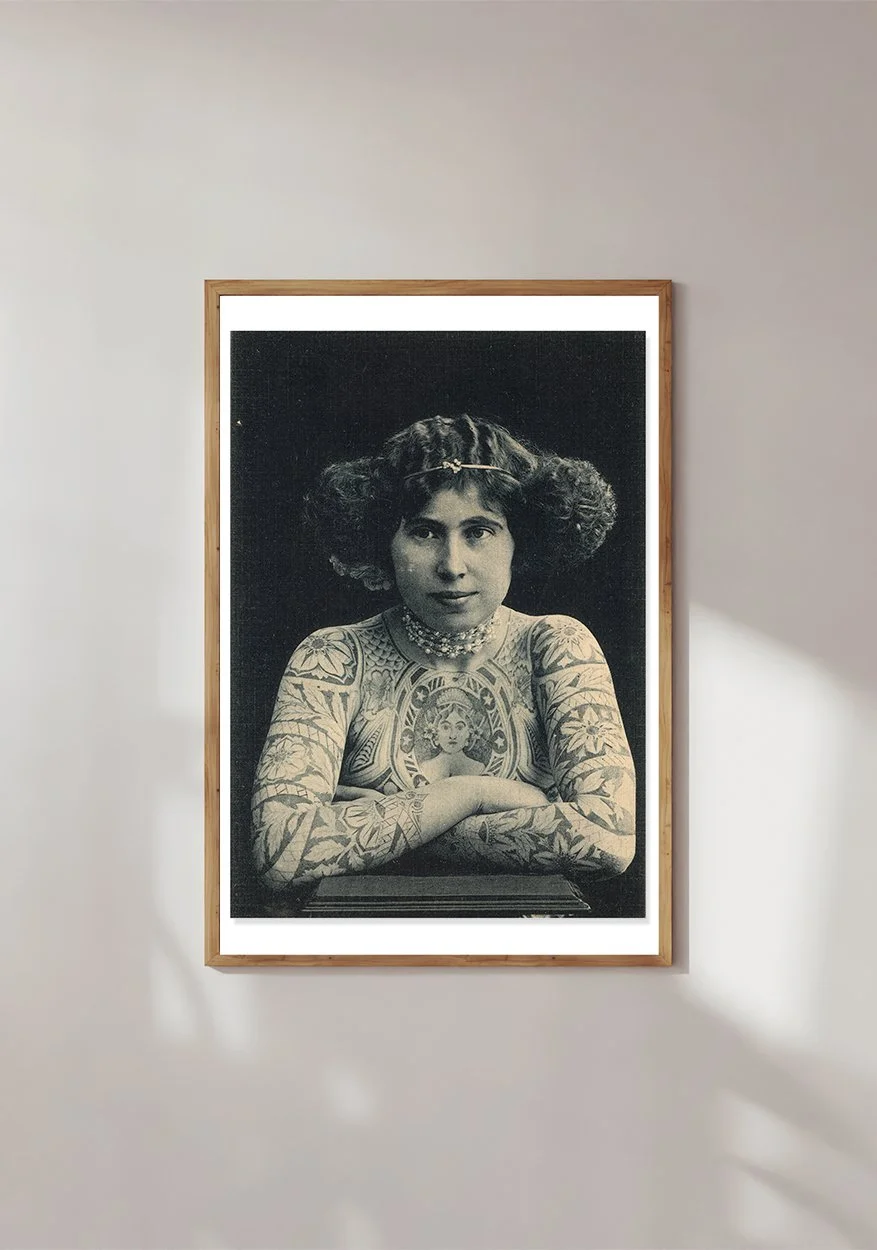 Framed head and shoulders vintage image of a tattoed lady in the early 1900s.