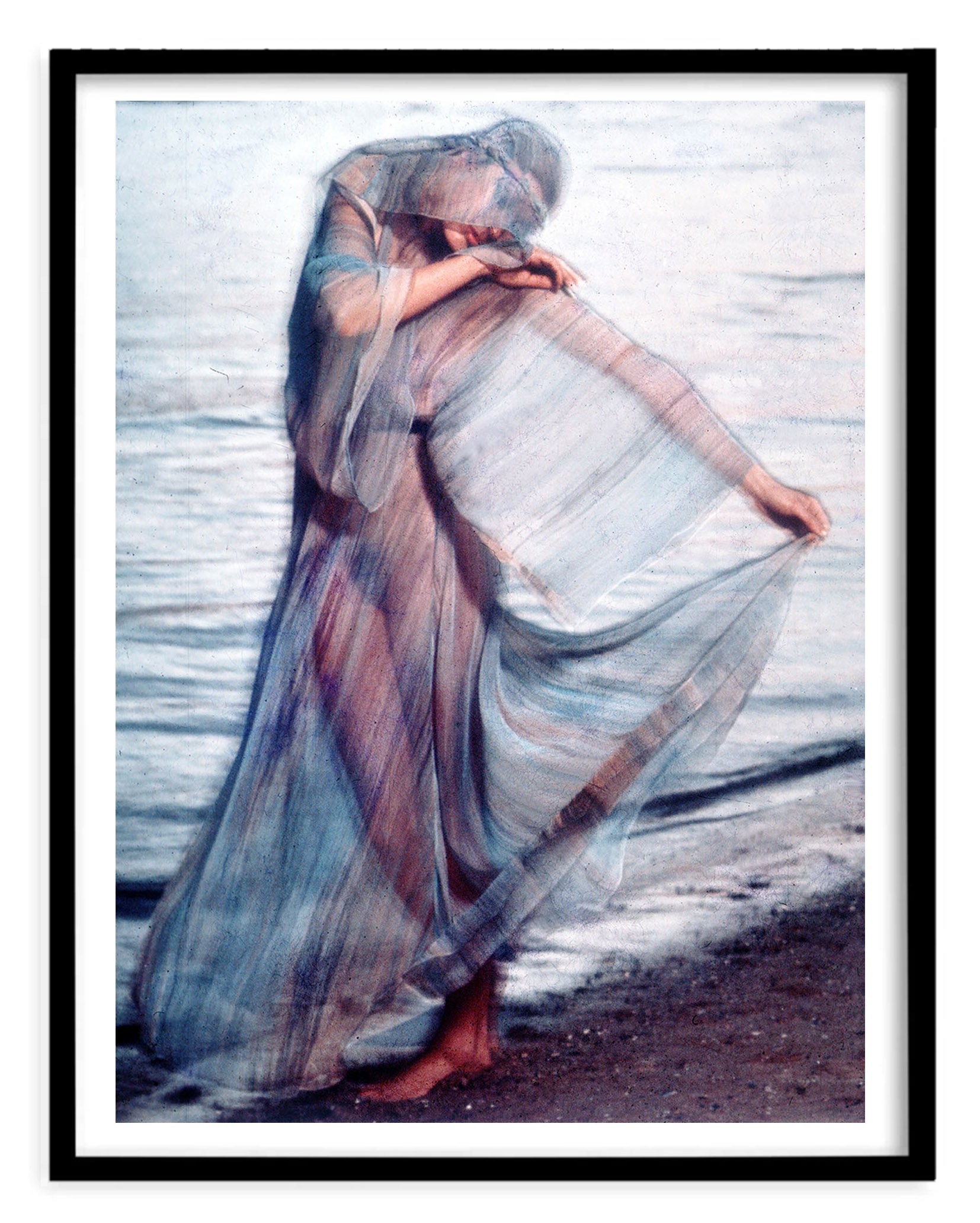 Black framed photographic image by Colin Beard of a girl in a floaty see-through dress on the beach in an astrology shoot for the Cancer star sign.