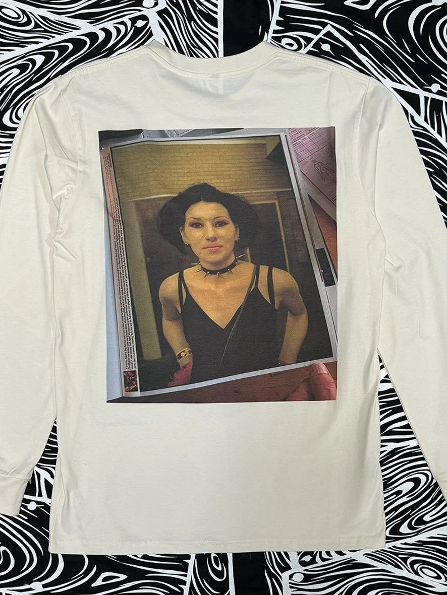 Back view of a natural long sleeved tee with a Peace Love and Brown Rice image of a woman with a black choker by Sophie Howarth.