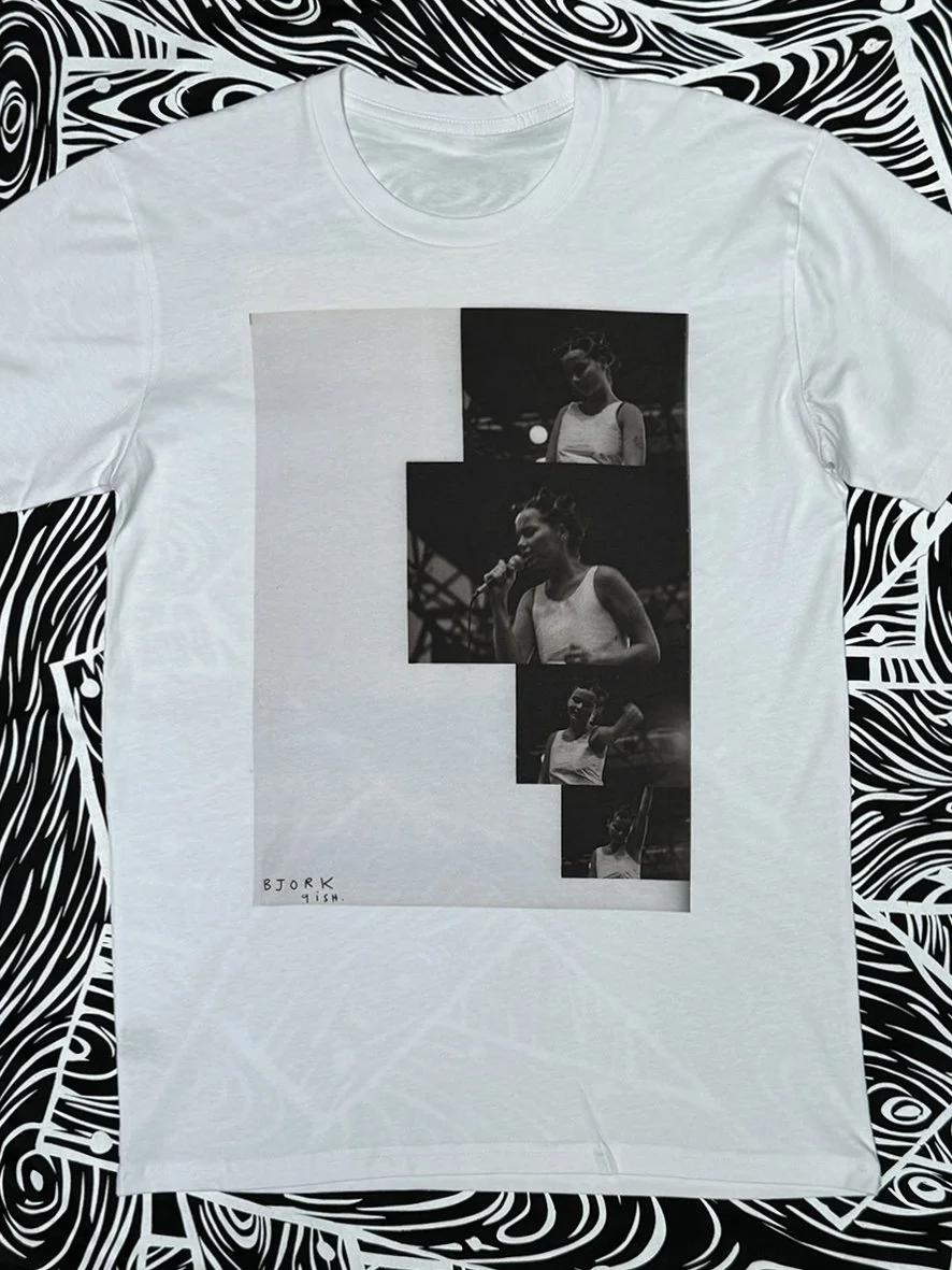 Front view of a white tee featuring a large print of Bjork from Sophie Howarth's Peace Love and Brown Rice photographs.